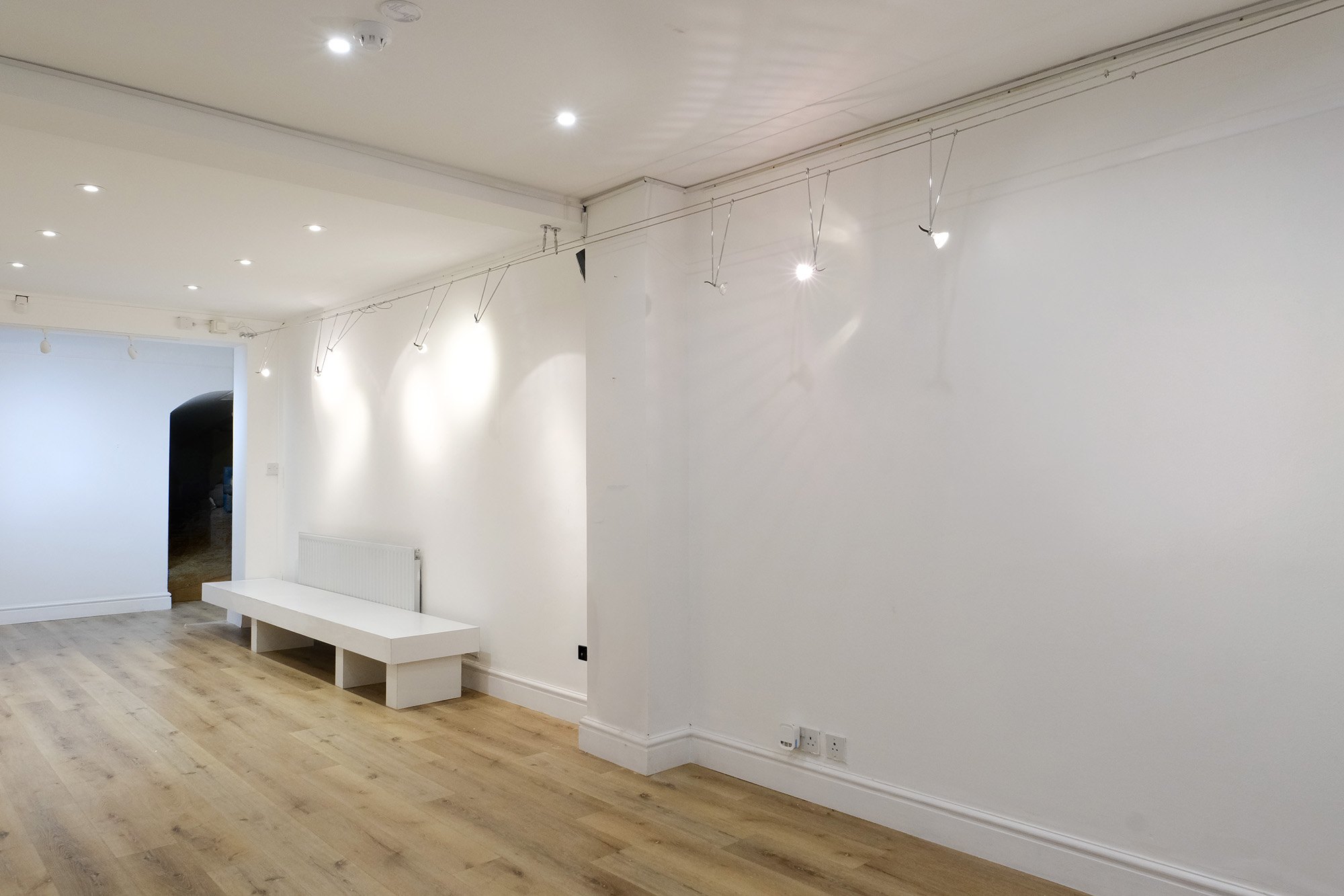 White walls and benches under gallery spotlights