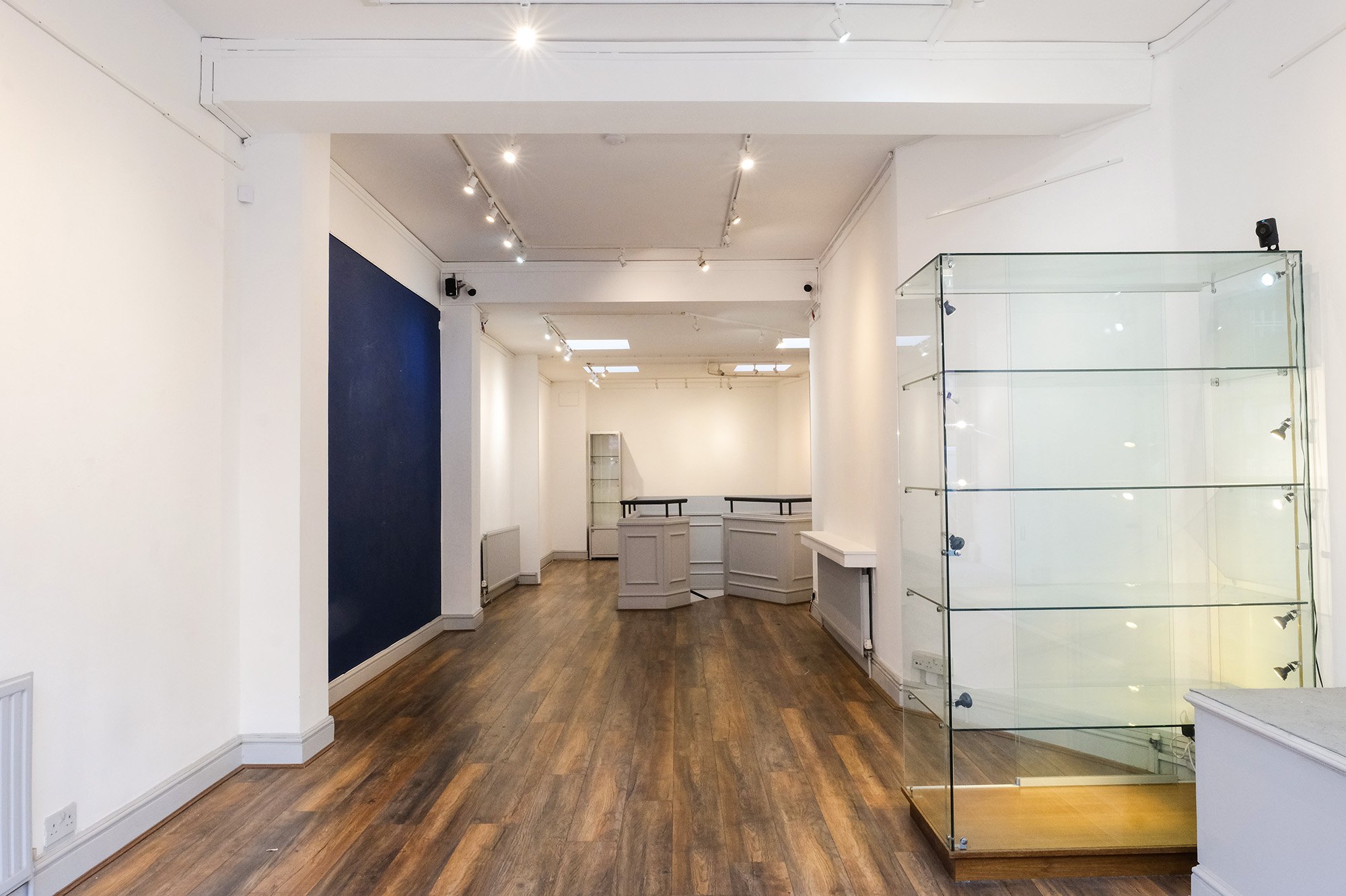 The full length of the top floor, with its navy feature wall and glass cabinets
